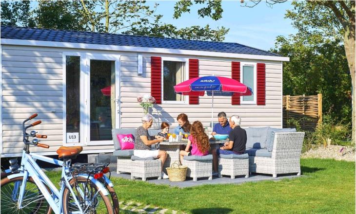 Familie op het terras van hun chalet op Vakantiepark de Oase in Renesse